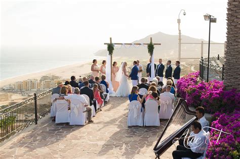 a wedding ceremony on the beach with purple flowers