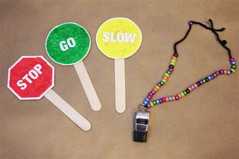 three lollipop sticks with the word slow painted on them and a lanyard