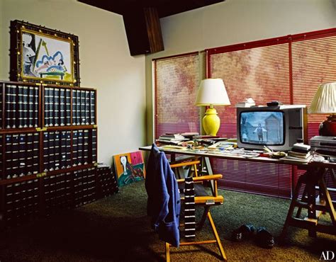 a desk with a television, lamp and bookshelf