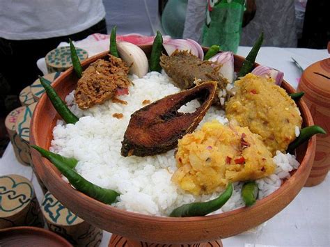 a bowl filled with rice, meat and vegetables on top of a white table cloth