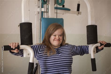 jeune fille trisomique sur un banc de musculation Photos | Adobe Stock