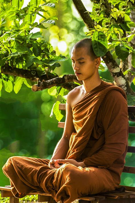 Royalty-Free photo: Man wearing brown monk suit while sitting on bench ...