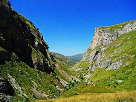 the mountains are covered in lush green grass