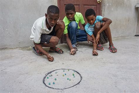 Haitian Boy Plans His Next Move in Marbles Game