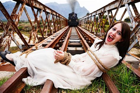 Victorian melodrama: steam train nears woman tied to railroad tracks by ...