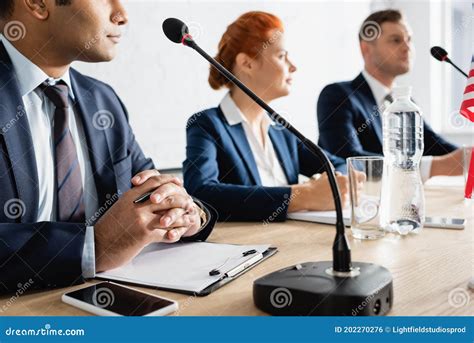 Multicultural Politicians Sitting Near Microphones During Royalty-Free ...