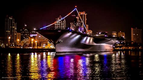 USS Midway aircraft carrier museum and city skyline lights at night on ...