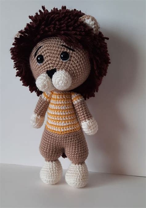 a crocheted stuffed animal is posed on a white surface and looks to the ...