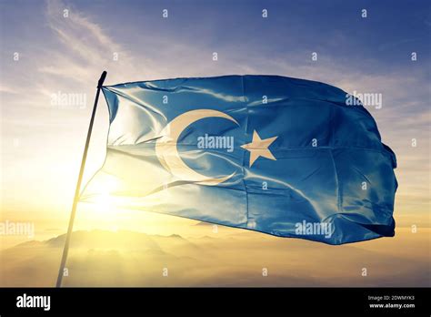 East Turkestan flag waving on the top sunrise mist fog Stock Photo - Alamy