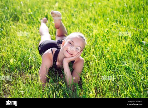 Cute happy little girl lying on the grass Stock Photo - Alamy