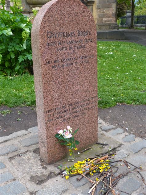 Greyfriars Bobby's grave - with flowers and sticks - Greyfriars Kirk