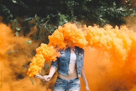 "Young Woman With Orange Smoke Bomb At The Nature ." by Stocksy ...