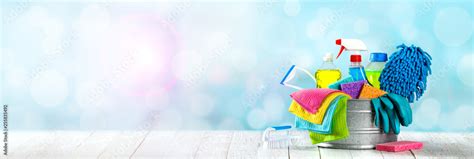 Bucket Of Cleaning Supplies On Wooden Table With Clean Blue Bubbly ...