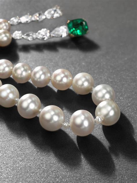 A rare natural pearl necklace with emeralds and diamonds,