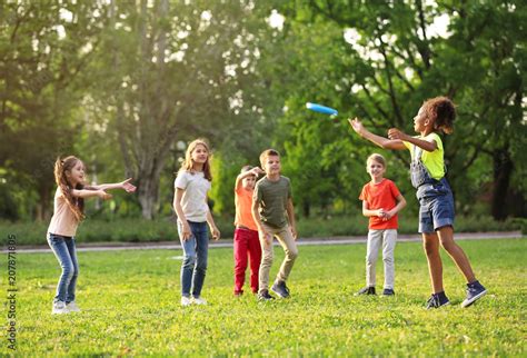 Cute little children playing with frisbee outdoors on sunny day Stock ...