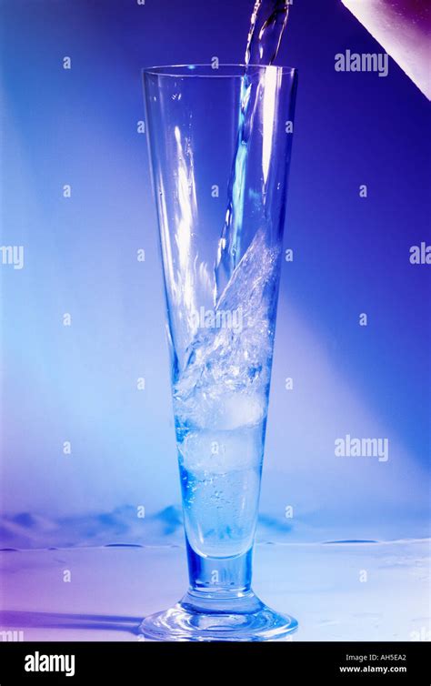 Water pouring into a tall glass with a blue and pink light Stock Photo ...