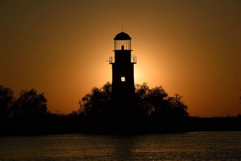 Premium Photo | Old lighthouse silhouette at sunset in sulinaromania