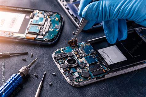 The asian technician repairing the smartphone's motherboard in the lab ...