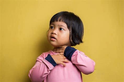 Premium Photo | Asian Little girl with sore throat touching her neck ...