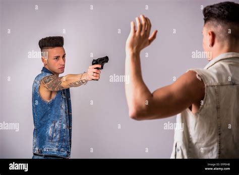 Young Man Pointing a Gun to Another Guy Stock Photo - Alamy