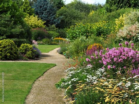 English garden with a grass lawns, summer flower borders, and ...