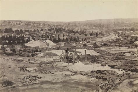 an old black and white photo of a town with lots of snow on the ground