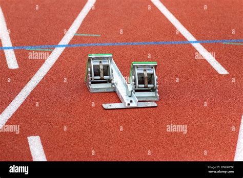 A track sprinters starting blocks set up on a red track Stock Photo - Alamy