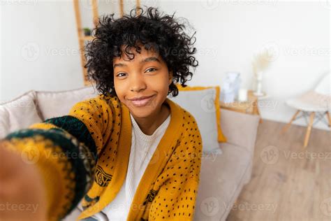 Happy african american teen girl blogger smiling face talking to webcam ...