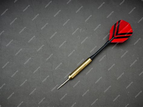 Premium Photo | Dart arrow with board on black granite