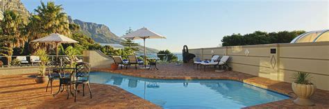 an outdoor swimming pool surrounded by patio furniture and umbrellas ...