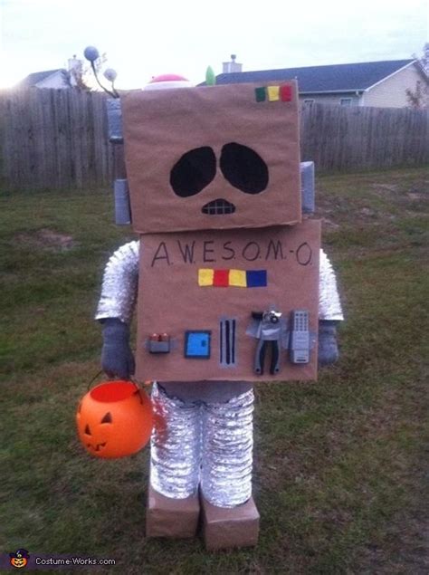 a cardboard robot with an orange pumpkin in his hand and the words ...