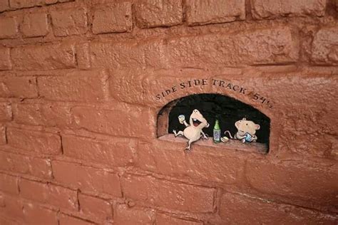 there is a brick wall with two small figurines in the hole on it