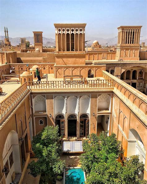 an aerial view of a courtyard with trees and buildings in the background