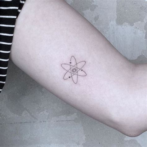 a woman's arm with a tattoo on it that has an object in the middle