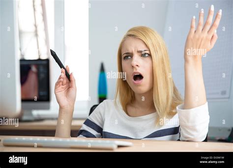 Angry young woman working on computer in office Stock Photo - Alamy