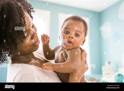 Black mother holding baby son Stock Photo - Alamy