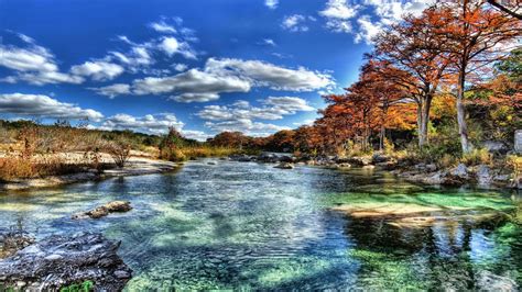 Download A River Surrounded By Trees And Rocks | Wallpapers.com