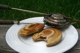 two pieces of bread on a white plate with an old fashioned tea kettle ...