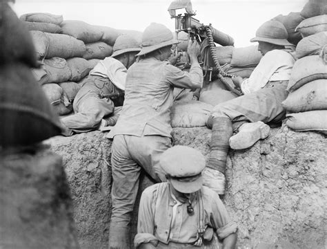 "A British soldier fires a machine gun with periscope attachment in the ...