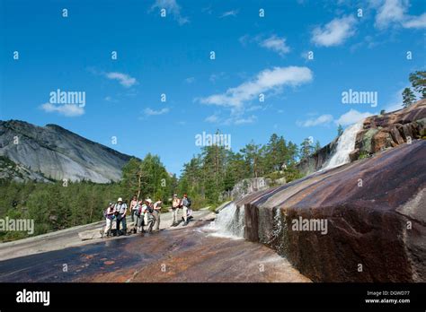 Hiking, trekking, hiking group standing at a waterfall, granite rocks ...