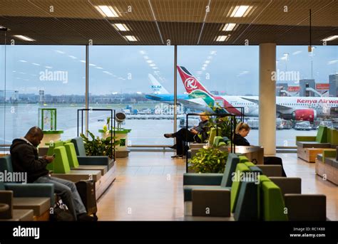 Passengers sitting in waiting area at a boarding gate at Amsterdam ...