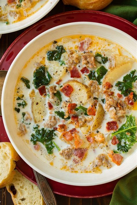 Zuppa Toscana soup in a white single serve bowl set over a red plate ...