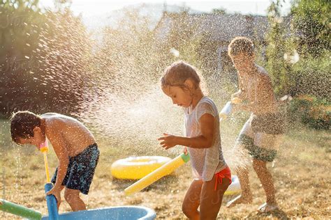 "Children Playing With Water Outdoors" by Stocksy Contributor "Dejan ...