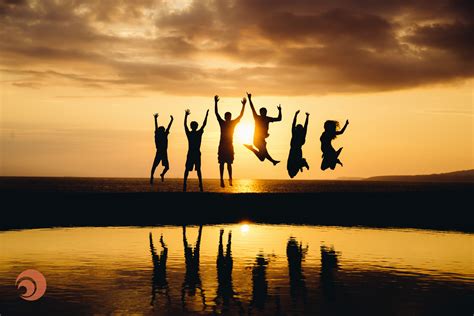 The silhouette of a family is visible jumping over the beach during a ...