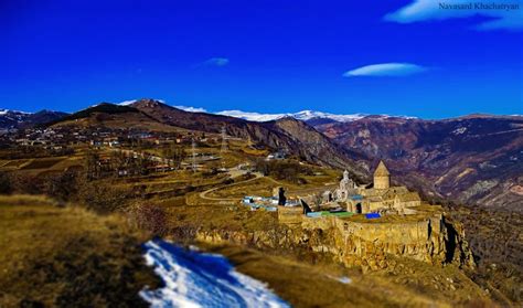 an old building on top of a hill with mountains in the background and ...