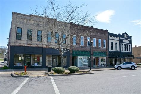 an empty street corner with cars parked on the side and buildings in ...