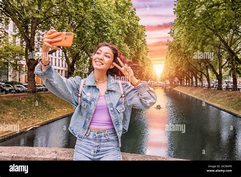 Happy girl travel blogger takes selfie pictures on her smartphone of ...