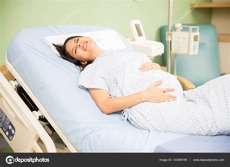 Woman getting labor contractions Stock Photo by ©tonodiaz 133095190