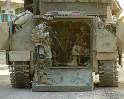 American and Iraqi troops share a Bradley fighting vehicle during a ...