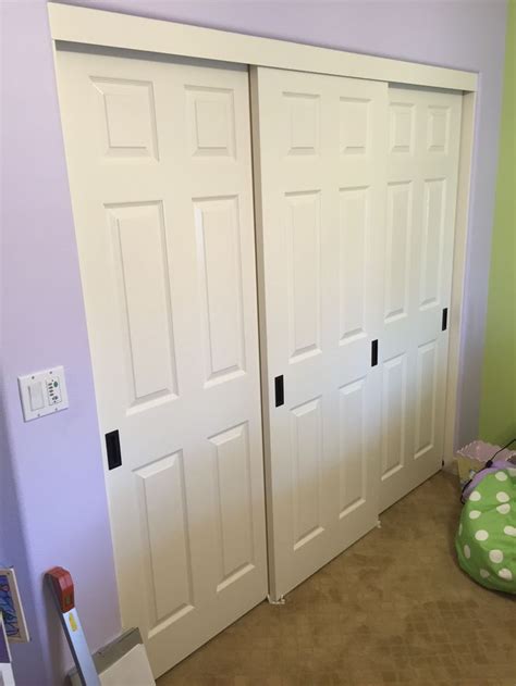 a room with two white doors and a green bean bag on the floor next to it